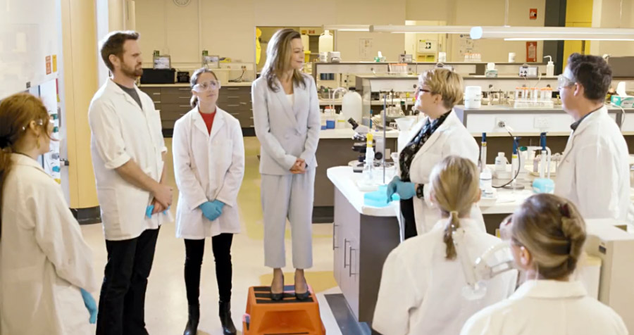 An executive addresses lab staff in a laboratory